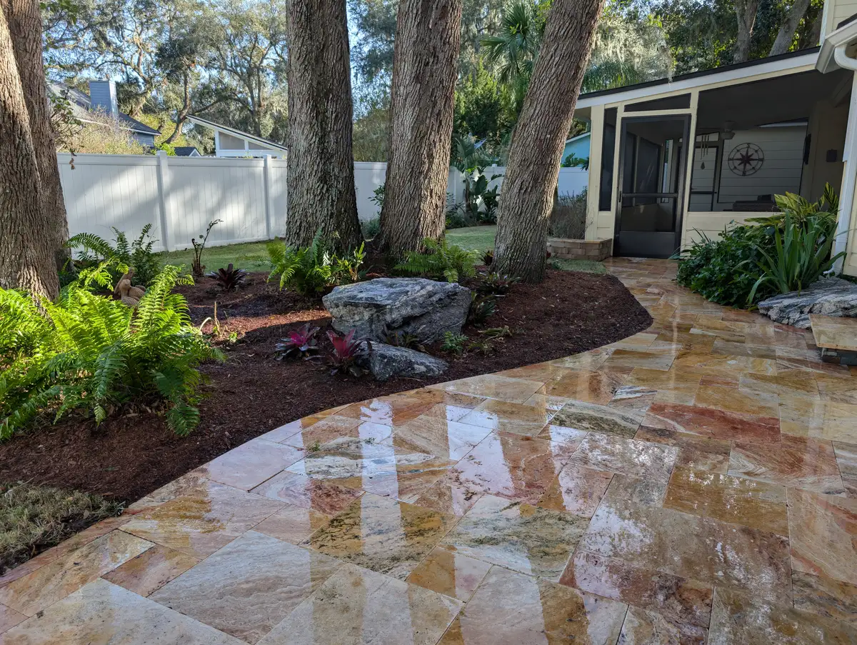 Natural stone patio surrounding trees and planting beds
