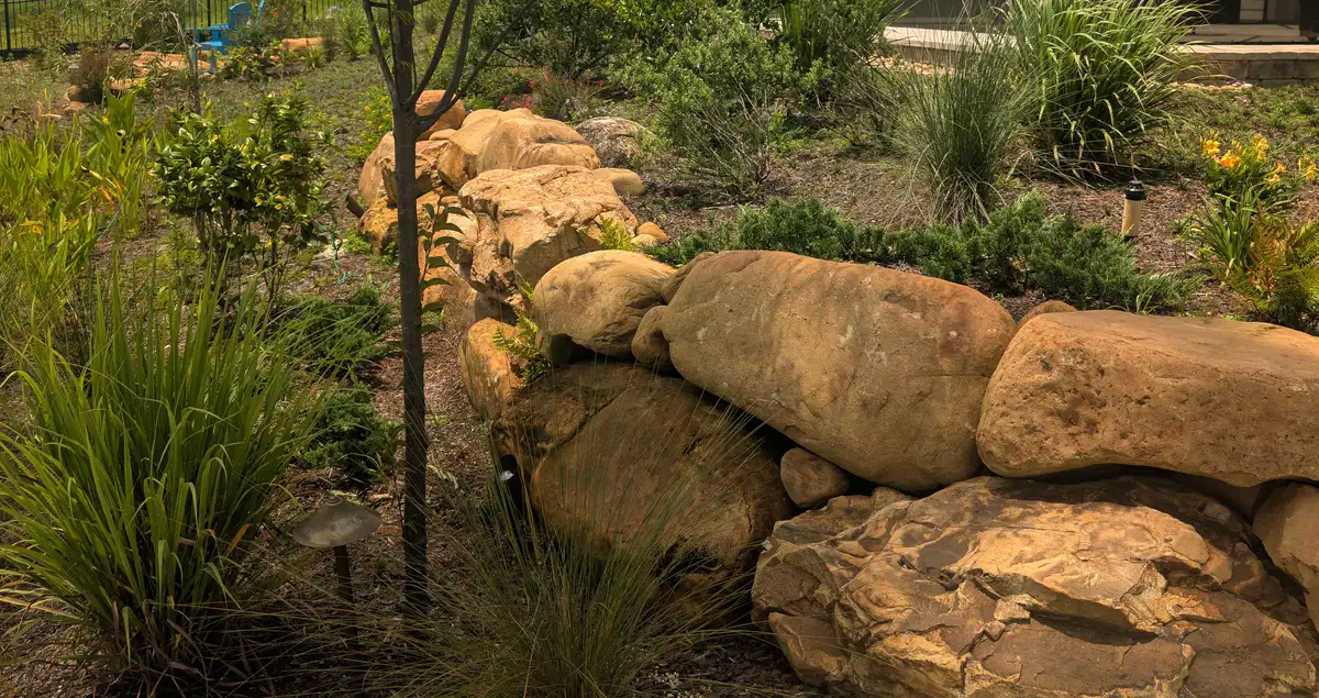 Boulder garden wall with grasses and planting above it